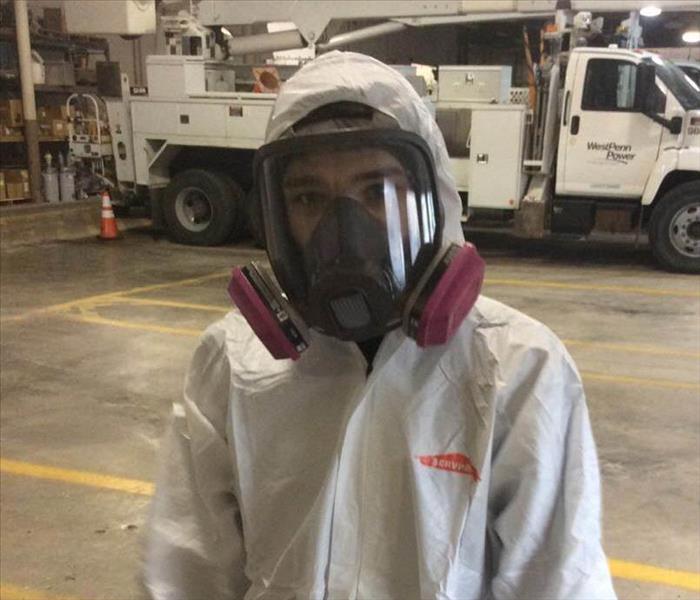 Employee suiting up for biohazard cleaning. 