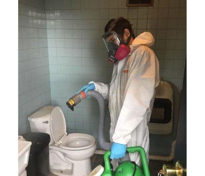 Employee disinfecting bathroom. 